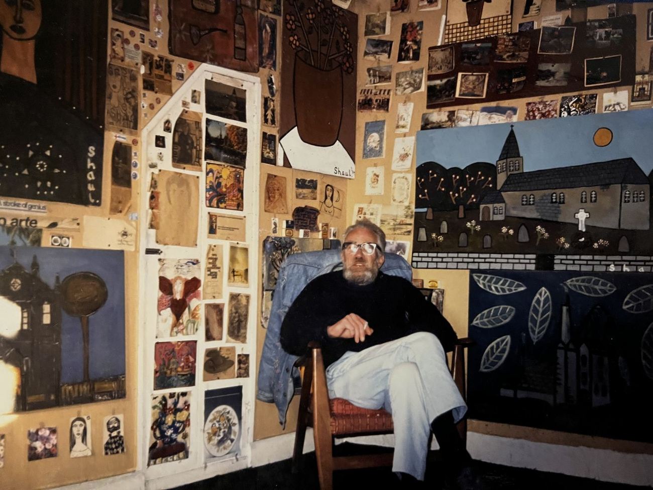 Terry Shaul in his cottage at Barripper, surrounded by his paintings and wall drawings